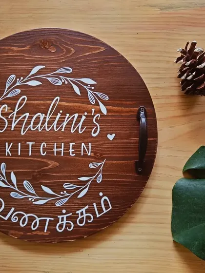 Another beautiful, personalized kitchen board, this one for "Shalini's Kitchen." The wreath design and "Vanakkam" greeting make it a warm and inviting piece.