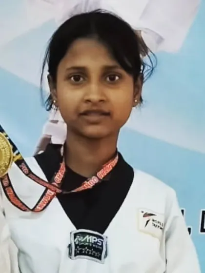A young student proudly shows off her gold medal from the 7th Warriors Taekwondo Championship.