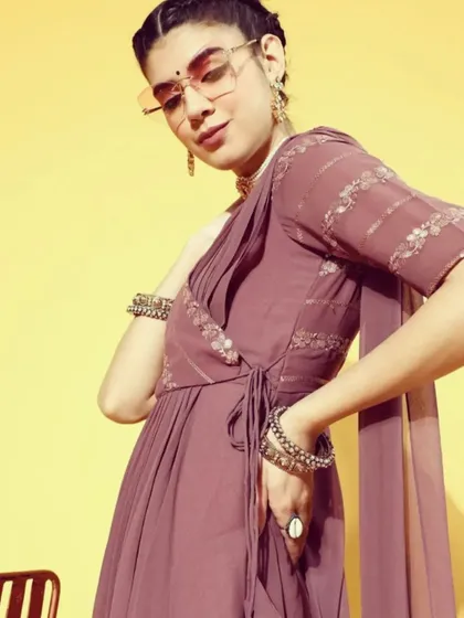A closer look at the mauve saree-dress, showing the wrap-style bodice with a side tie-up and the delicate sequin detailing. It's a chic and comfortable option for any party.