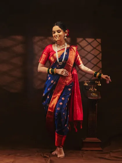 A dynamic pose that shows the flow and movement of the saree. The vintage telephone prop adds a nice touch.
