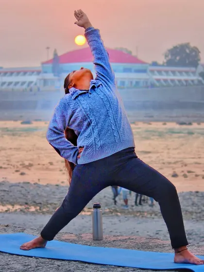 A student practicing Viparita Virabhadrasana (Reverse Warrior) against a beautiful sunrise. This image perfectly captures the feeling of finding peace and strength within, connecting with the sky above and the earth below.