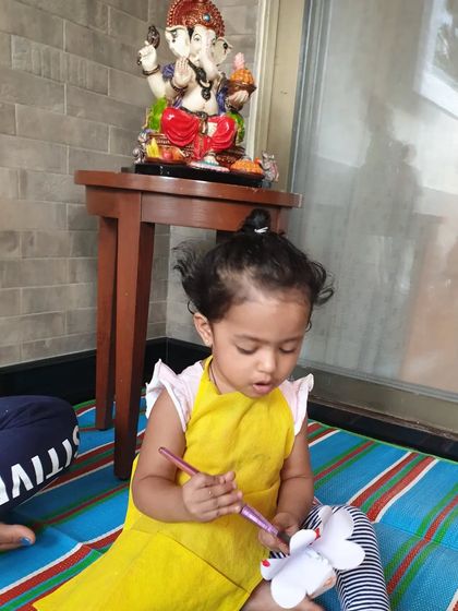 A quiet moment of creativity during our Ganesha celebration. This little girl is painting a flower offering, with a Ganesha idol in the background.