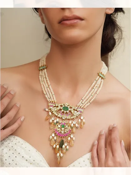 A beautiful layered necklace with a unique pendant, combining pearls, polki, and colorful gemstones for a festive look.