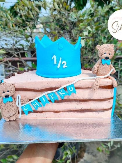 A cute half-cake for a six-month birthday celebration. This design features two adorable teddy bears and a blue crown, perfect for marking the halfway point to one.