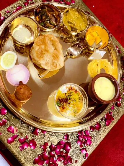 A feast for the eyes and the palate. This is a look at a complete Royal Thali, featuring a curated selection of premium North Indian vegetarian dishes like rich dals, paneer, fluffy puris, and traditional sweets.