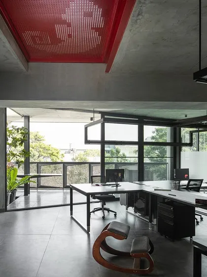Our own design studio, 'Project 113', is a testament to our philosophy. The open-plan workspace is designed for collaboration, with large windows for natural light and a material palette of concrete and steel. The red perforated steel ceiling detail adds a pop of color and character.