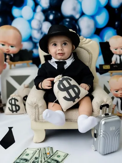 This little boss is in charge. The full setup with the backdrop, props, and costume creates a complete story.