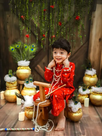 A moment of divine mischief. This little Kanha, dressed in red with his pearl necklaces, looks absolutely adorable in our rustic Janmashtami setup.