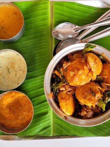 A bowl of our flavorful podi idlis, served with three different chutneys for a variety of tastes in every bite.