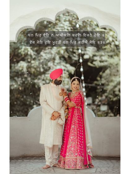 A beautiful portrait of Avikash and Simran, framed by a traditional Indian archway, their pink and white outfits creating a soft, romantic look.