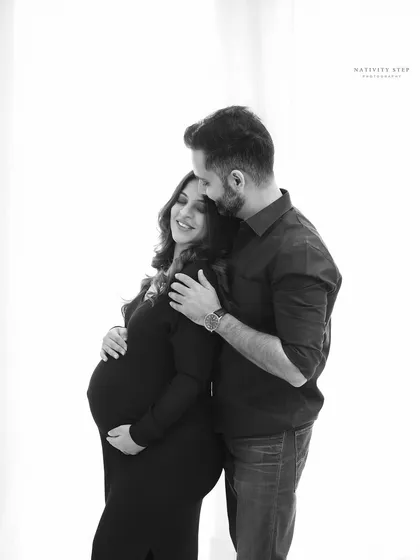 Sometimes, the quiet moments are the most powerful. This black and white couple's portrait uses high-contrast lighting to focus purely on the intimate connection and shared joy between the parents-to-be.