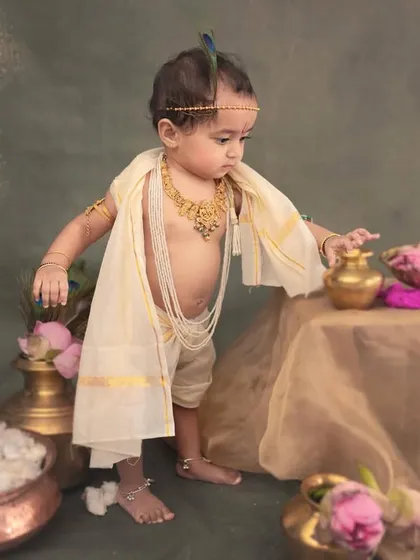 A standing pose for a curious baby. He reaches for the props, giving us a dynamic and engaging portrait that captures his developing motor skills.