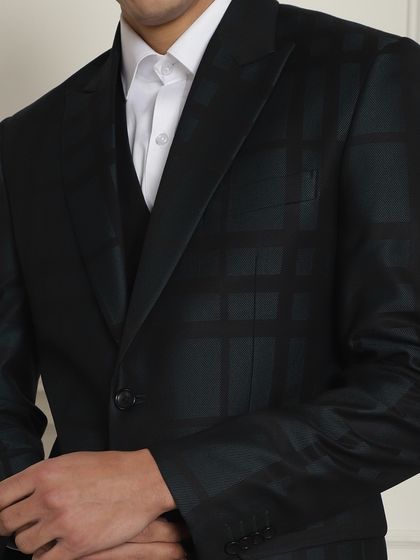 A close-up of a dark green plaid suit. This is a subtle way to incorporate pattern and color into your formal wardrobe.