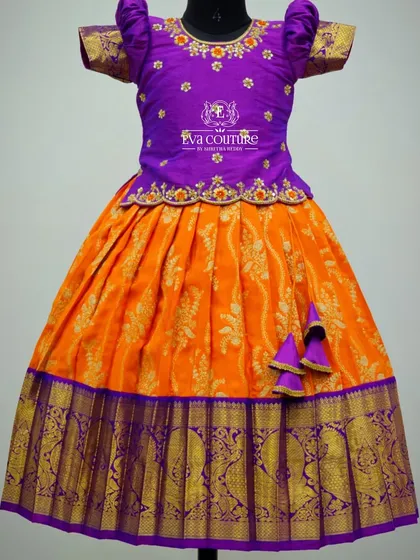 Another look at the orange and purple Banarasi lehenga, showing the puff sleeves and cute tassels.