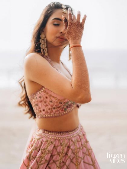 A creative and artistic bridal portrait on the beach. The pose is natural and emotive, capturing a moment of quiet contemplation.