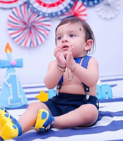 Clapping with excitement for his first birthday! We capture all the happy moments, from playing with toys to getting ready for the cake.