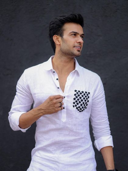 A model wearing the white linen kurta with a checkered pocket, exuding confidence and modern style.
