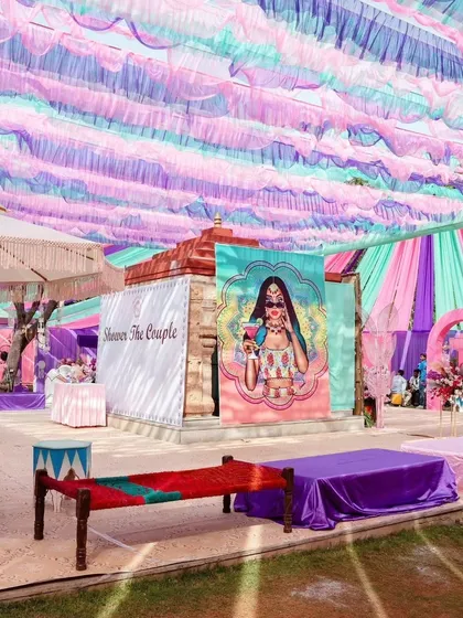 The vibrant and colorful hues of a carnival-themed Haldi. We used pastel fabric draping for the ceiling and quirky, artistic banners to create a fun and festive environment.
