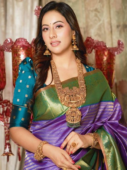 A close-up portrait of Dr. Shruthi, her temple jewelry and beautiful saree creating a look of timeless elegance.