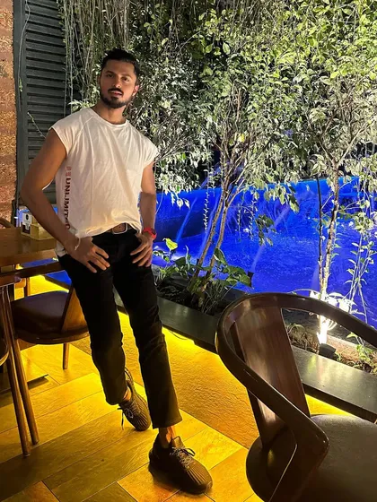 Posing against a vibrant blue waterfall background, this shot has a cool, modern vibe.