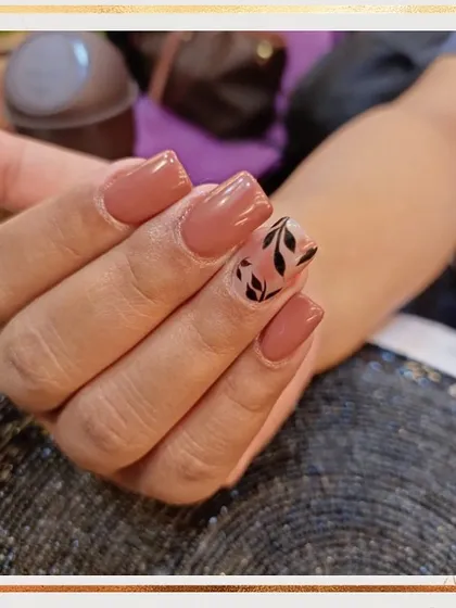 A simple and chic design for everyday wear. This set features a warm nude base with a single accent nail on each hand with a hand-painted black leaf pattern.