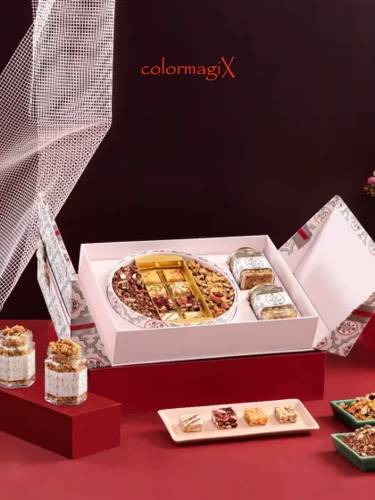 This sophisticated white hamper opens to reveal a curated selection of premium dry fruits and nuts. It's a healthy yet luxurious gift, ideal for corporate clients or health-conscious loved ones.