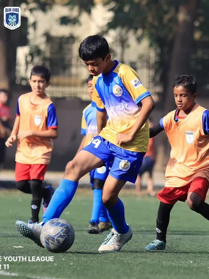 Our player skillfully maneuvering the ball between two opponents in a U11 Thane Youth League game.