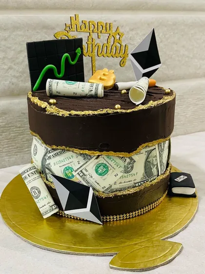 Your passions, baked into a cake. This custom two-tier design was for a crypto enthusiast, featuring edible money, Ethereum symbols, and a Bitcoin topper on a rich chocolate cake.