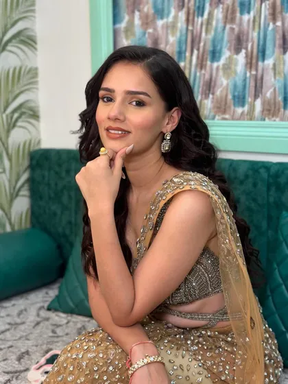 A thoughtful pose that highlights the delicate jewelry and the flawless makeup application around the eyes and cheeks.