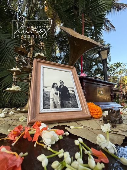 A close-up of the gramophone and framed photo, surrounded by fresh flowers.