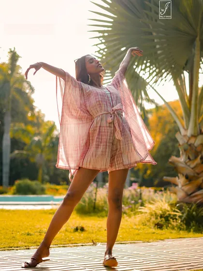 Capturing the free-spirited vibe of a resort wear collection. This outdoor shoot uses the golden hour sun to create a warm, natural glow, highlighting the flow and texture of the fabric as the model strikes a dynamic pose.
