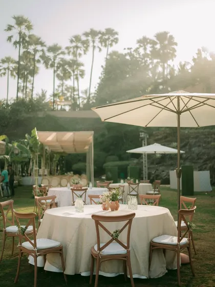 The guest seating area for the garden wedding, featuring simple wooden cross-back chairs and tables with terracotta centerpieces.