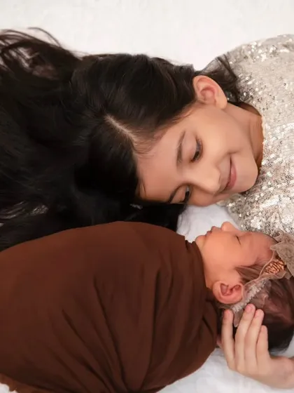 The beginning of a lifelong bond. This tender moment between a big sister and her newborn sibling is what we strive to capture, the quiet, unscripted stories that define your family.