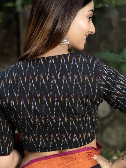 The back view of our black ikat blouse. The traditional pattern of the fabric is the highlight, offering a timeless look that is both ethnic and chic.