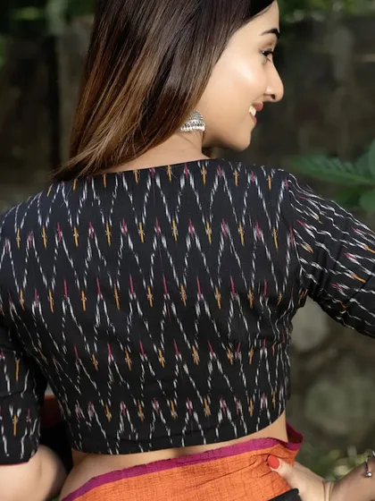 The back view of our black ikat blouse. The traditional pattern of the fabric is the highlight, offering a timeless look that is both ethnic and chic.