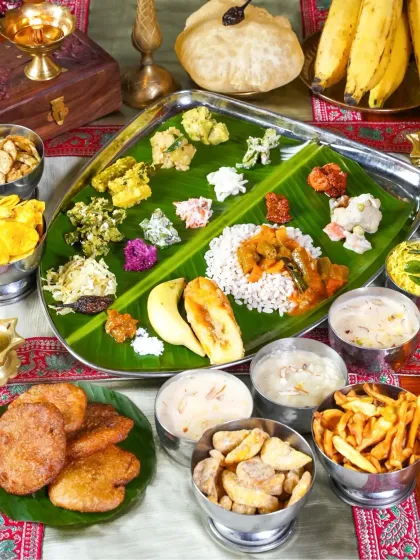 A complete Onam Sadhya served on a banana leaf, featuring a wide array of traditional dishes. The bright, even lighting captures the freshness and variety of this festive Keralite meal.