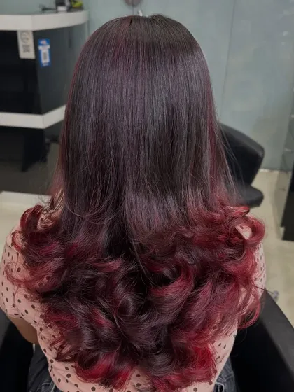 For clients who want a bold yet elegant change, I love creating looks like this plum red ombre. The color melts from a natural dark base into vibrant red ends, styled with soft curls to show off the color gradient. This is a great way to express your personality.
