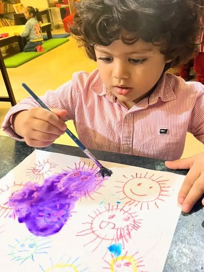 This curly-haired artist is having a wonderful time painting with watercolors. The smiles on their faces are the best part of my day.