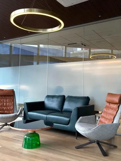 The waiting area in the BKC One office features sophisticated leather seating and a striking circular pendant light. The design creates a comfortable and impressive space for clients.