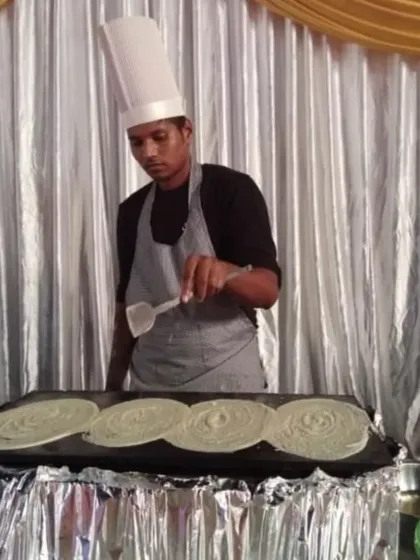 My interactive live counters are always a hit with guests. Here you can see one of my chefs preparing fresh, hot dosas on a large tawa, providing both a delicious meal and an engaging experience for everyone at the party.
