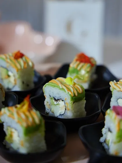 A close-up of our expertly prepared sushi rolls, drizzled with sauces and ready to be served. We bring the finesse of Japanese cuisine to your vegetarian corporate event.