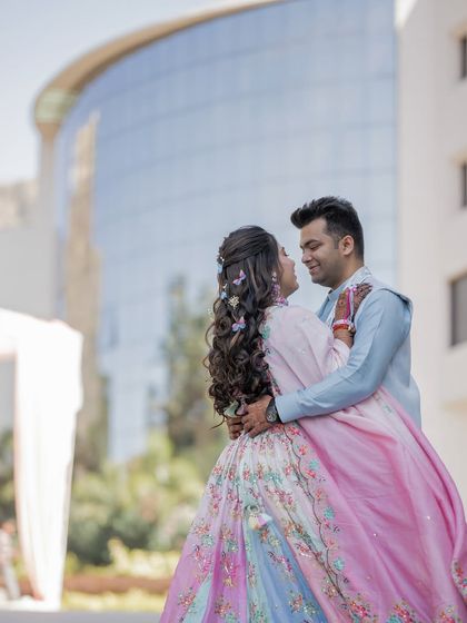 A beautiful portrait with the couple in a loving embrace, set against a modern architectural background.