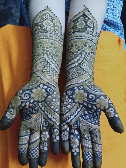 This design features a beautiful blend of dark, filled-in floral patterns on the palm with lighter, more open work on the forearm.