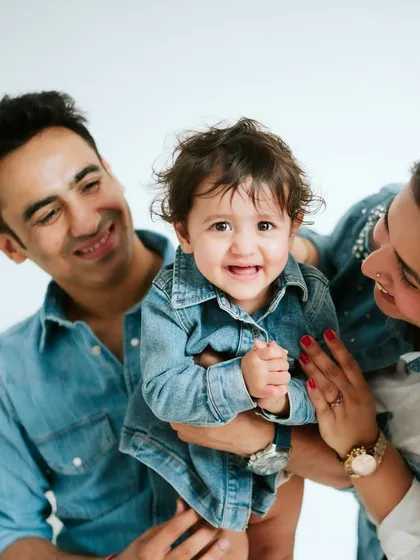 A close-up of pure family joy. The focus is on their happy faces and the love they share.