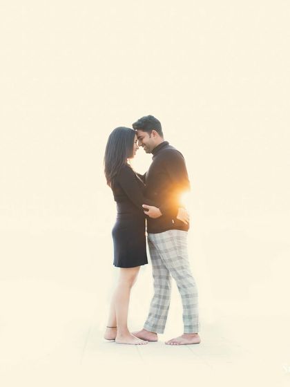 A minimalist, high-key portrait of a couple against a bright, sunlit background. The simplicity of the shot emphasizes their connection.