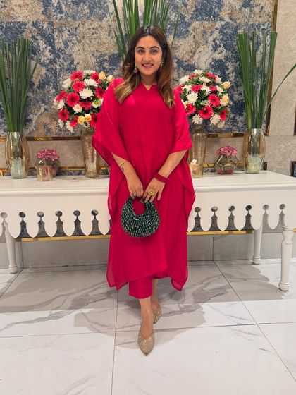 Great styling starts with the color wheel. Here, I've paired a bold pink kaftan set with a contrasting green bag for a balanced and eye-catching look that is perfect for a festive brunch.