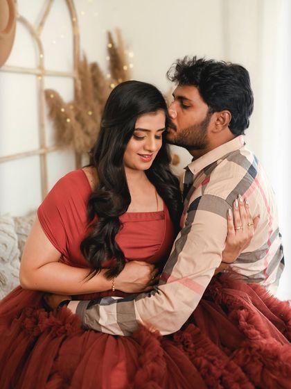 A tender kiss on the cheek. This cozy studio shot is filled with warmth and affection, perfectly capturing the love between the parents to be.
