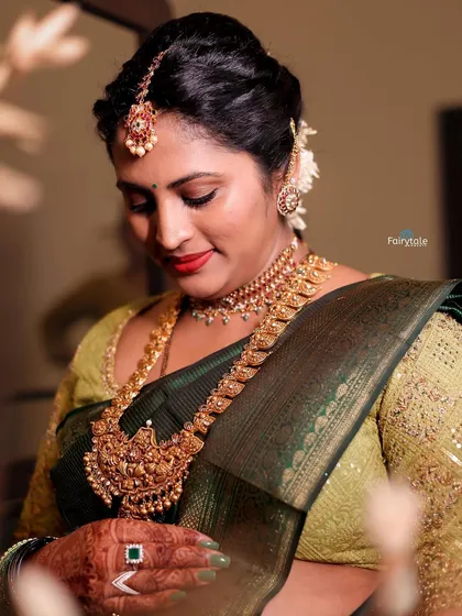 A beautiful mother-to-be glowing in a dark green saree. Her custom light green blouse is fully embroidered, adding a touch of elegance to her baby shower look.