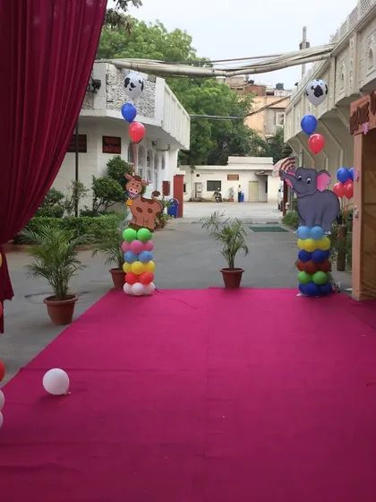 An outdoor entrance setup for a jungle-themed party. We use colorful balloon pillars with animal cutouts to line the pathway, creating an exciting safari experience from the moment guests arrive.