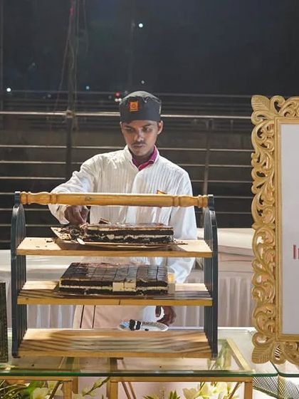 Indulge in a symphony of sweetness at our International Dessert Stage. Here, one of our chefs prepares a decadent layered chocolate dessert, showcasing the artistry and variety available at our dessert counters.